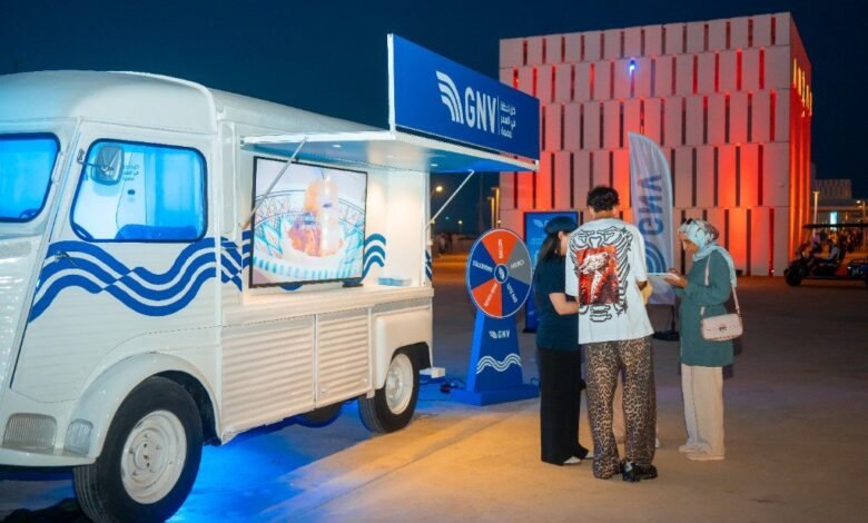 Van GNV blanc aux vagues bleues transformé en kiosque mobile, avec roue des cadeaux, à Tanja Marina Bay à Tanger